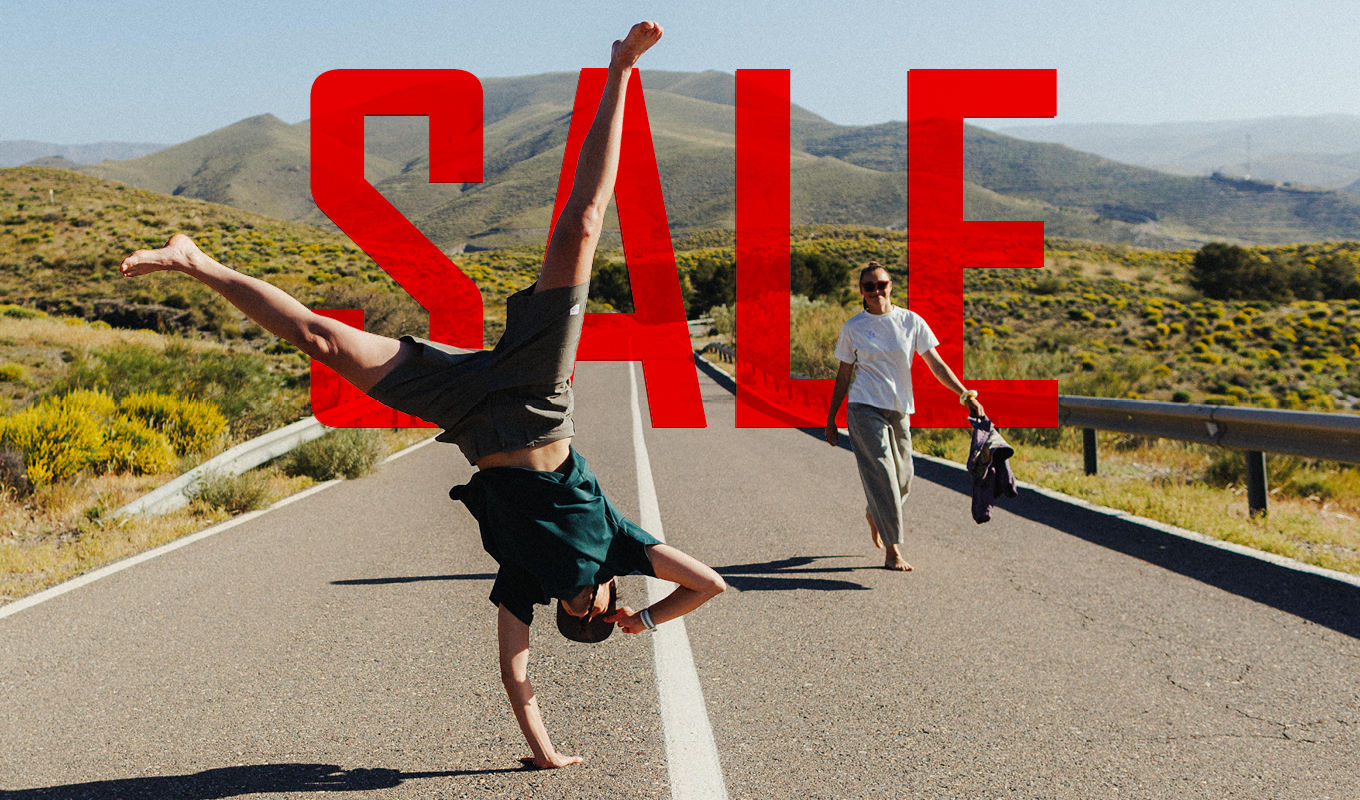 Sommer-Sale-Motiv mit zwei Personen auf einer sonnigen Straße, eine davon im Handstand. Dazu die Aufschrift „SALE – 20 % Rabatt – Der Sale für dein Abenteuer“.