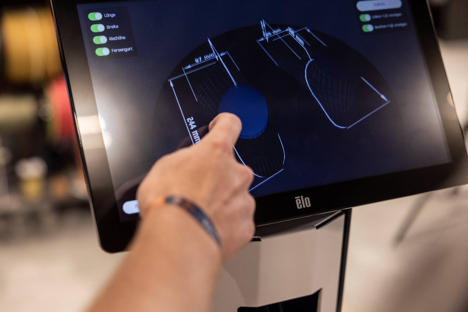 3D Fußanalyse Ein Mann zeigt auf einen Bildschirm mit 3D Fußanalyse